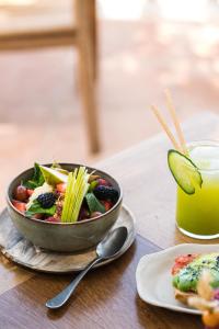 a bowl of salad and a plate of food and a drink at Hostal La Torre Ibiza Cap Negret in San Antonio