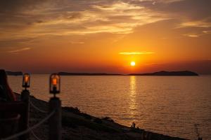 a sunset over a body of water with the sun setting at Hostal La Torre Ibiza Cap Negret in San Antonio