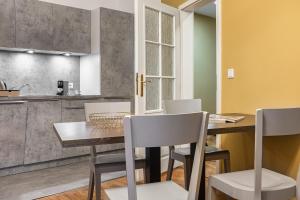 Il comprend une cuisine et une salle à manger avec une table et des chaises en bois. dans l'établissement VN48 Suites by Adrez, à Prague