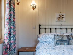 a bedroom with a bed with blue and white sheets at 1 Bed in Ironbridge 77906 in Leighton