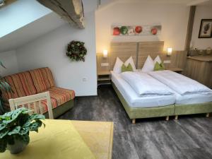 une chambre d'hôtel avec un lit et un canapé dans l'établissement Wirtshaus am Treidelpfad, à Haßmersheim