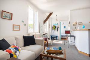 Una sala de estar con un sofá blanco y una mesa. en Appart' confort Les Maôves Parking privé, en Étretat