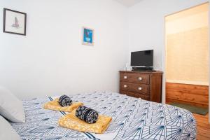 Un dormitorio con una cama con dos almohadas y un televisor. en Appart' confort Les Maôves Parking privé, en Étretat