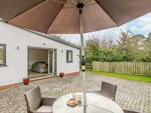 a table with an umbrella on a patio at 2 bed in Crediton 66576 in Nymet Tracey