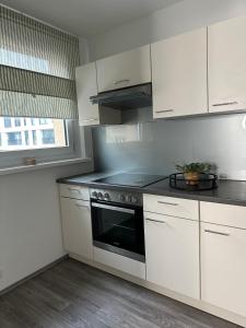 a kitchen with white cabinets and a stove top oven at Appartement Elena in Linz