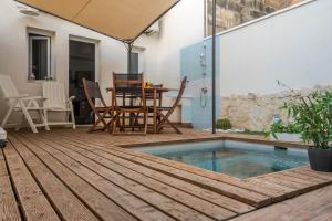 a patio with a pool and a table and chairs at CapoSud - Suite Fiocco in Marina di Ragusa
