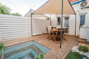 a patio with a table and an umbrella at CapoSud - Suite Fiocco in Marina di Ragusa