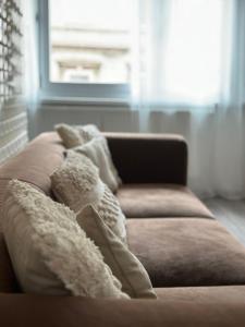 ein Sofa mit Kissen darauf im Wohnzimmer in der Unterkunft Appartement Elena in Linz