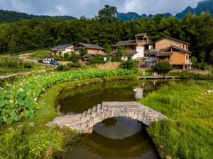 a stone bridge over a river in a village at Dayong Antique Feature Resort in Zhangjiajie