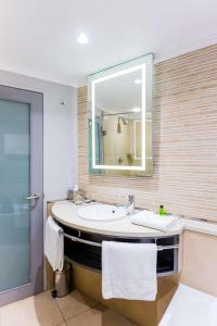 een badkamer met een wastafel en een spiegel bij Garden Court Hatfield in Pretoria