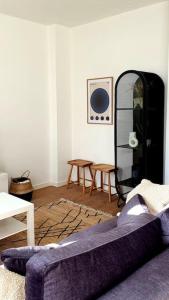 a living room with a purple couch and a table at The South Suite - trendy duplex op het Zuid in Antwerp