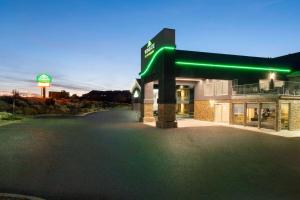 a building with a green sign on the side of it at Wingate by Wyndham Cedar City in Cedar City