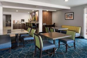 a restaurant with tables and chairs and a kitchen at Wingate by Wyndham Cedar City in Cedar City