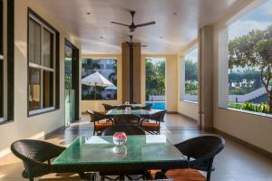 a living room with tables and chairs and windows at Sterling Puri in Puri