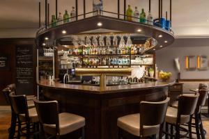 a bar in a restaurant with chairs around it at Vienna House by Wyndham Thüringer Hof Eisenach in Eisenach