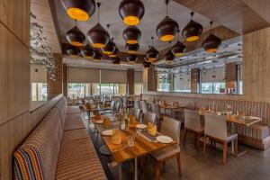 a restaurant with wooden tables and chairs and lights at Sterling Puri in Puri