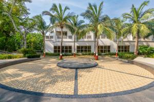 a courtyard in front of a building with palm trees at Sterling Puri in Puri