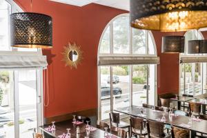 comedor con paredes y ventanas de color rojo en Villages Clubs du Soleil - LA BAULE, en La Baule