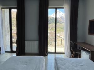 a bedroom with two beds and a view of a mountain at Shushabandi Kazbegi in Kazbegi