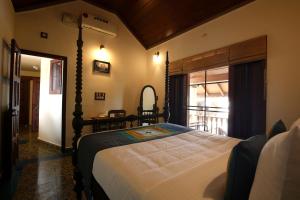 a bedroom with a bed and a window with a balcony at The Mundanad House in Trivandrum +15 photos