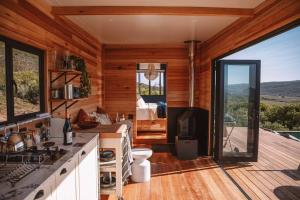 a room with a kitchen with a view of a bedroom at Solace Eco Cabins - Tea Cabin in Clanwilliam