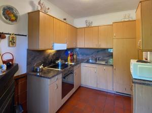 een keuken met houten kasten, een wastafel en een fornuis bij Casa Bellavista in Lugano