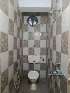 a small bathroom with a toilet and a shower at Spacious Flat - Centrally Located in Hyderabad
