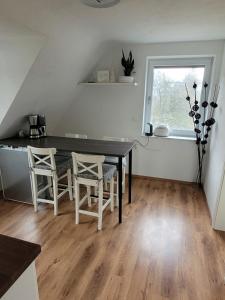 ein Esszimmer mit einem Tisch, Stühlen und einem Fenster in der Unterkunft Apartment Ferienwohnung Steigwaldweg in Würzburg