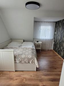 ein weißes Schlafzimmer mit einem Bett und einem Fenster in der Unterkunft Apartment Ferienwohnung Steigwaldweg in Würzburg