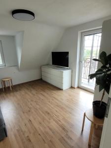 ein Wohnzimmer mit einem Flachbild-TV auf einer Kommode in der Unterkunft Apartment Ferienwohnung Steigwaldweg in Würzburg