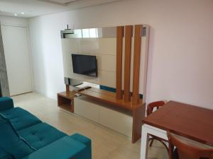 a living room with a blue couch and a television at Apartamento 509 Gravataí in Gravataí