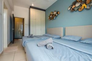 twee bedden in een kamer met blauwe muren bij The Houz@Midhill Genting Highlands (Free Wi-Fi) in Genting Highlands