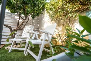 two white chairs sitting on top of a yard at CapoSud - Suite Randa in Marina di Ragusa