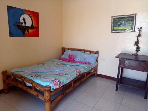 a bedroom with a wooden bed with a pink blanket at Malapascua Be One Guesthouse in Malapascua Island