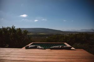 a deck with a pool with a view of the mountains at Solace Eco Cabins - Citrus Cabin in Clanwilliam