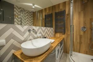a bathroom with a white sink and a shower at VacationClub – Bukowa 17A Apartament E.2 in Wisła +12 photos