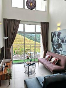 sala de estar con sofá y ventana grande en W3WarmStay@GoldenHills/3RPenthouse/WiFi/PasarMalam/2carpark, en Brinchang