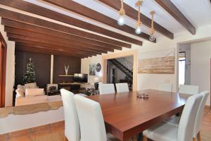 uma sala de jantar com uma mesa de madeira e cadeiras brancas em Villa Es Triquet 151 by Mallorca Charme em Binissalem