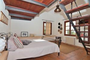 ビニサレムにあるVilla Es Triquet 151 by Mallorca Charmeの白いベッドと木製の天井が備わるベッドルーム1室が備わります。