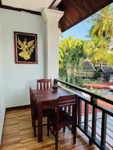 a dining room with a table and chairs on a balcony at Singrarat Hotel in Luang Prabang