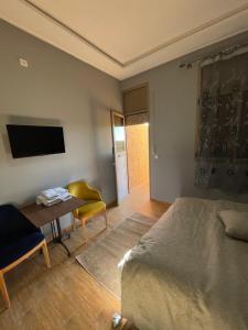 1 dormitorio con cama, mesa y TV en Palms Garden en Erfoud