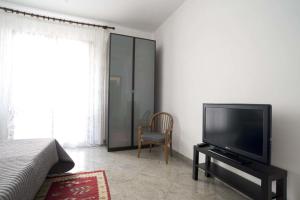 a bedroom with a flat screen tv and a chair at Relais Chiesa Madre - Rooms and Apartments in Misterbianco