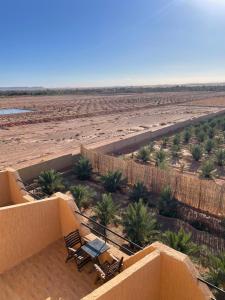 einen Balkon mit Stühlen und Blick auf die Wüste in der Unterkunft Palms Garden in Erfoud
