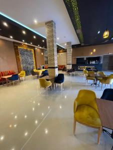 a lobby with chairs and tables in a building at Palms Garden in Erfoud