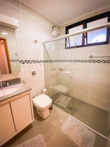 uma casa de banho com um WC e uma cabina de duche em vidro. em Lindo apto com lazer completo em Aguas de Lindoia em Águas de Lindoia