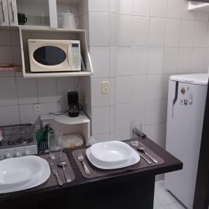 a kitchen with a counter with two plates and a microwave at Apartamento Barão da Torre in Rio de Janeiro
