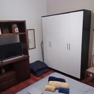 Apartamento Barão da Torre في ريو دي جانيرو: غرفة نوم مع خزانة بيضاء كبيرة وتلفزيون