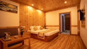 a bedroom with a bed in a room with wooden walls at THE CONIFER in Manāli