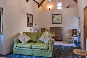 a living room with a green couch and a table at Finest Retreats - Swallows at St Keverne in Saint Keverne