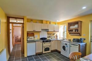 a kitchen with white appliances and yellow walls at Finest Retreats - Swallows at St Keverne in Saint Keverne